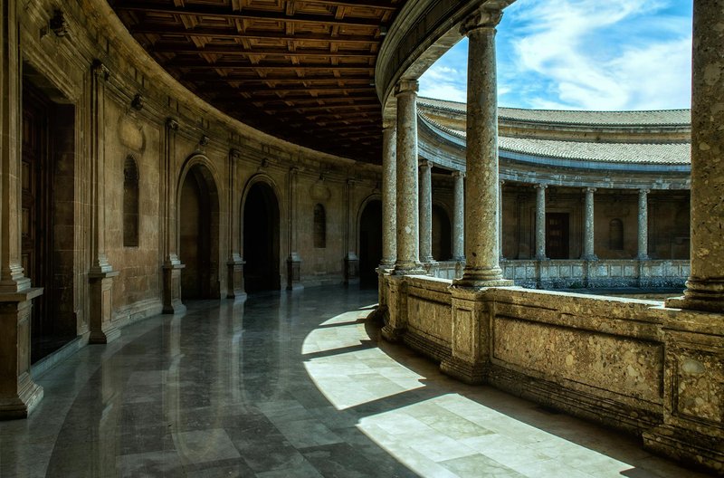 Runder Innenhof des Palastes Karls V. in der Alhambra mit zweigeschossiger Kolonnade aus Stein und Holzdecke im Stil der Renaissance.
