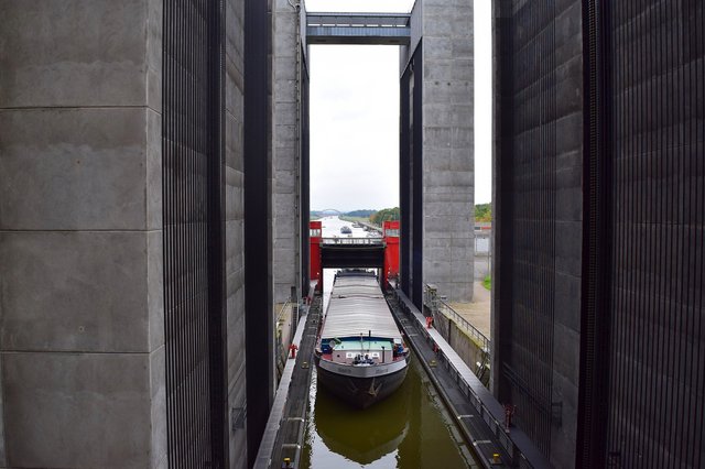 Ein Frachtschiff in der Kammer des Schiffshebewerks Scharnebeck bei Lüneburg, flankiert von massiven Betonpfeilern mit Blick auf den Elbe-Seitenkanal