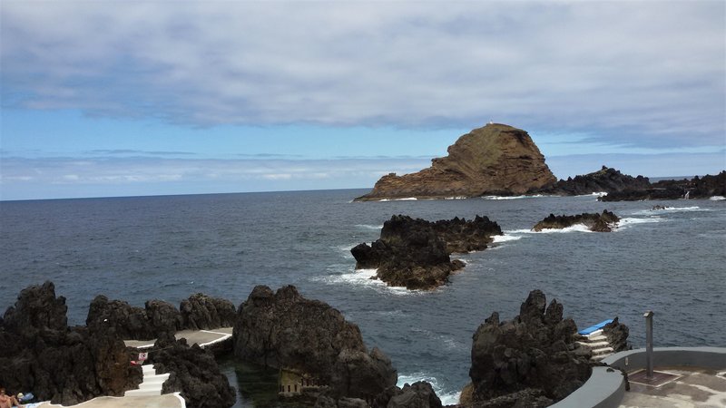 Dramatische Lavaküste mit natürlichen Meeresschwimmbecken von Porto Moniz – im Hintergrund ragt der vulkanische Felsen Ilhéu Mole aus dem Atlantik auf.