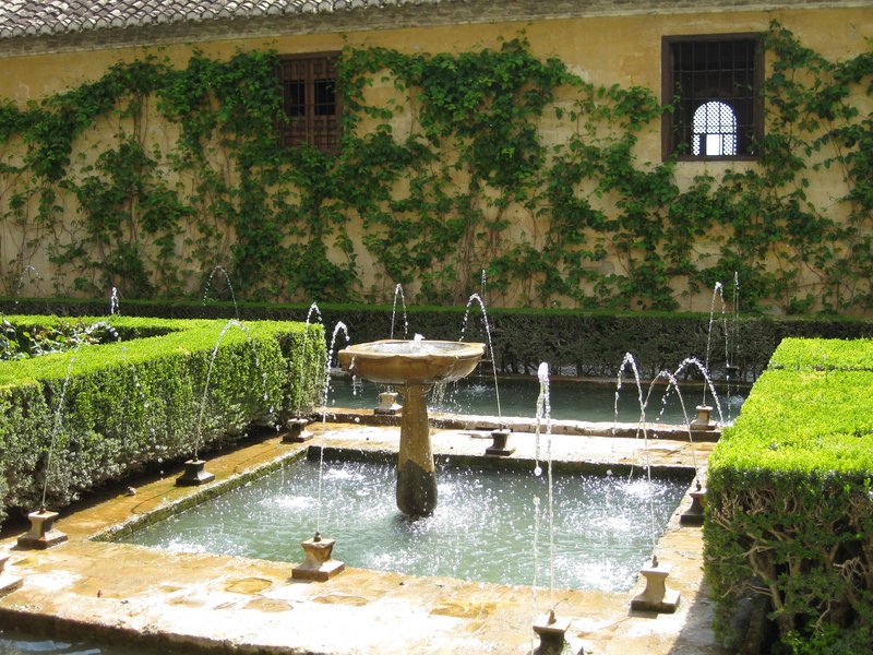 Islamischer Garten mit zentralem Brunnenbecken und Wasserspielen im Generalife der Alhambra, der den maurischen Herrschern als Rückzugsort zur Erholung außerhalb der offiziellen Palastbereiche diente.