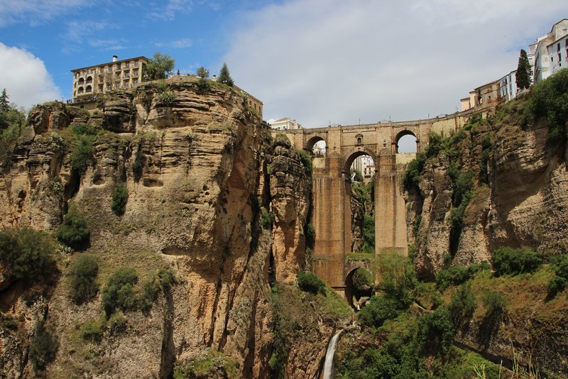 Spektakuläre Ansicht von unten auf die Puente Nuevo in Ronda über der Schlucht El Tajo mit Wasserfall.
