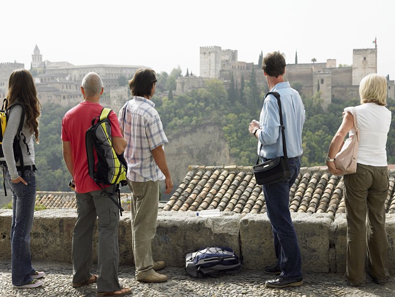Reisegruppe blickt vom Mirador de San Nicolás im Albaicín auf die Alhambra in Granada