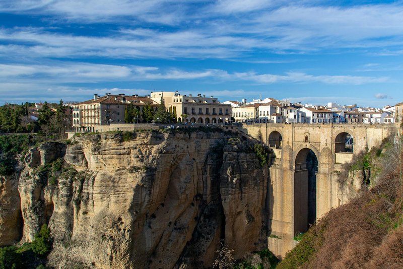 Die Puente Nuevo in Ronda, die sich majestätisch über die Schlucht El Tajo spannt, mit Blick auf die angrenzende Altstadt und die dramatisch abfallenden Felswände – ein Symbol andalusischer Ingenieurskunst aus dem 18. Jahrhundert.