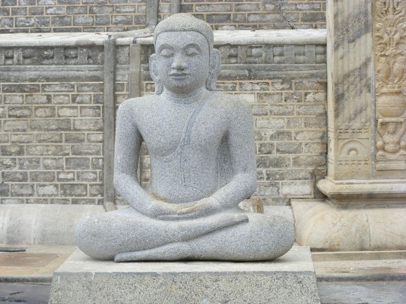 Buddha-Statue in Meditationshaltung vor Tempelmauer in Anuradhapura, einer der ältesten Städte Sri Lankas
